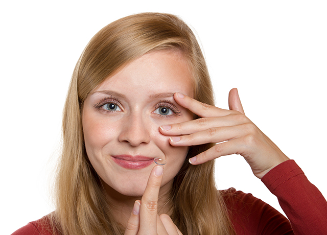 Kobieta zakłada soczewkę kontaktową na oko.
